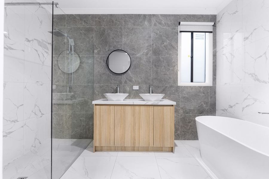 Modernes, hochwertig saniertes Badezimmer mit Doppelwaschtisch und freistehender Badewanne